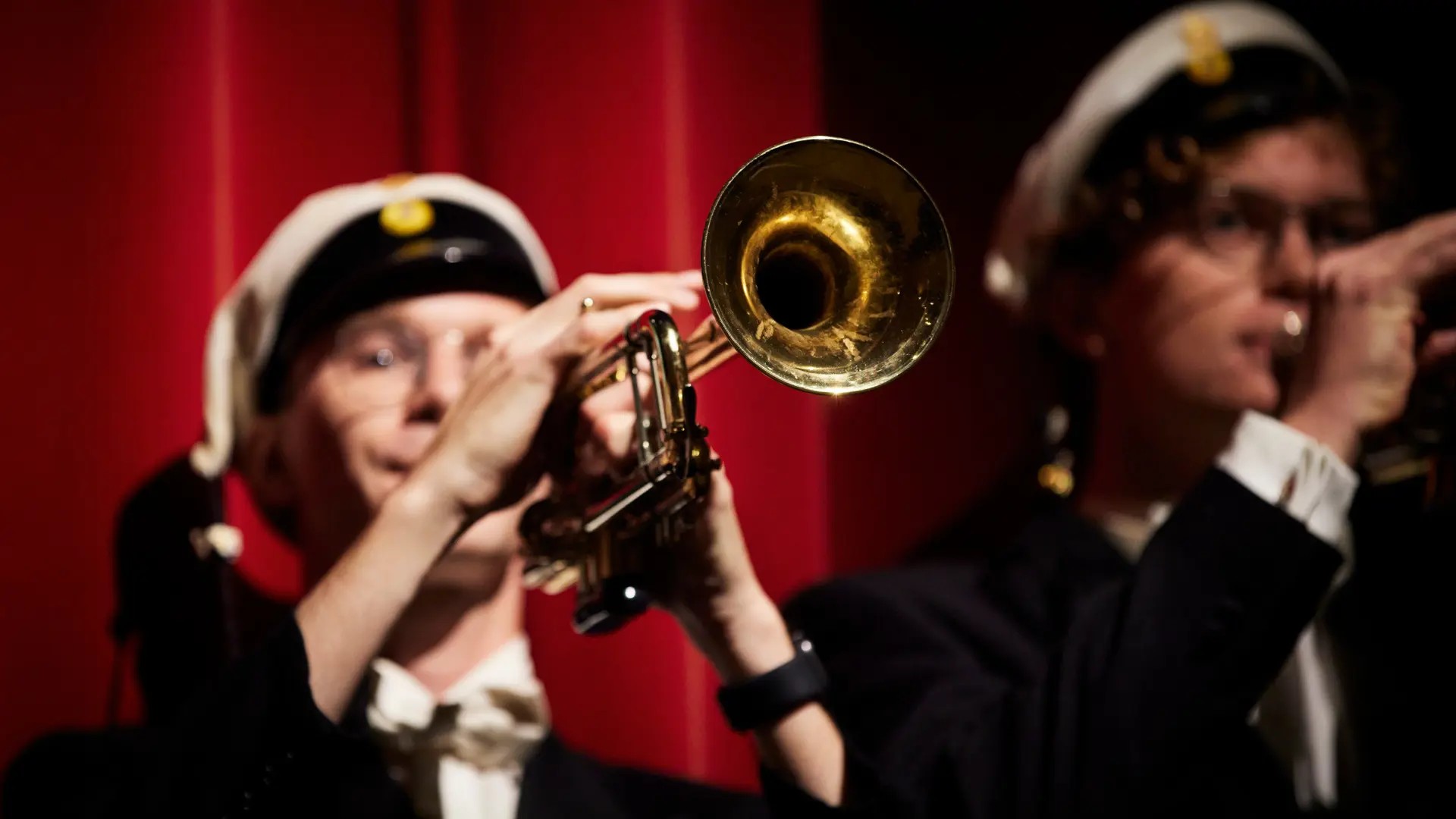 Students blowing trumpets.