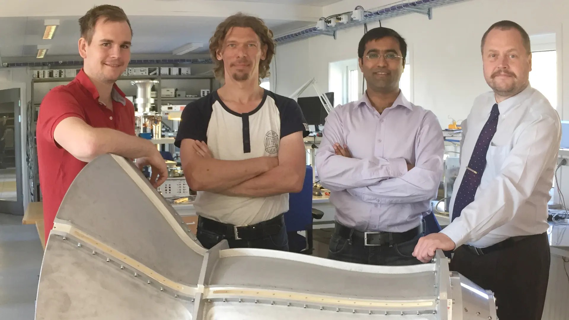 The Band 1 feed in the electronics lab at Onsala Space Observatory. Standing behind the feed horn from the left: Joel Schleeh (Low Noise Factory) with Onsala Space Observatory engineers Magnus Dahlgren, Bhushan Billade (technical project manager) and Jens Dahlström. (Credit: SKA Organisation)  